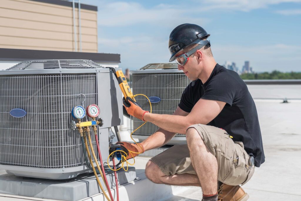 HVAC technician inspecting and servicing an outdoor air conditioning unit using refrigerant gauges and diagnostic tools.