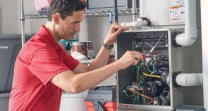 HVAC technician inspecting and repairing a heating system’s internal components.